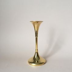 a gold vase sitting on top of a white table