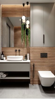 a modern bathroom with wood paneling and white fixtures