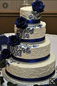 a three tiered wedding cake with blue roses