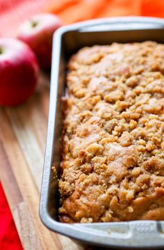 an apple crumb cake in a pan on a cutting board