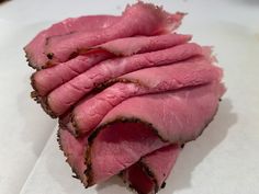 sliced meat sitting on top of a piece of paper