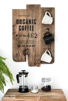 a wooden sign hanging on the side of a wall with coffee cups and mugs