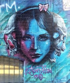 graffiti painted on the side of a building with a woman's face and two butterflies