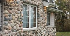 a stone house with white trim and windows