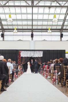 a bride and groom are walking down the aisle