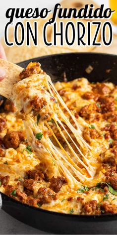 a skillet filled with cheesy meat and cheese is being held by a spatula