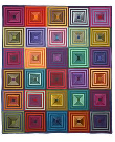 a colorful quilt hanging on the wall