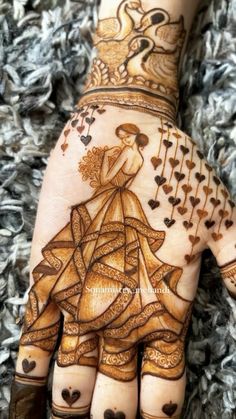 the hand is decorated with henna designs on it's fingers and hands, as well as hearts