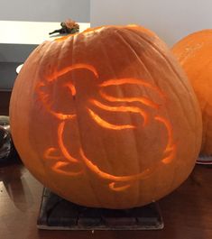 two carved pumpkins sitting on top of a table