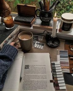 a person is sitting at a table with some books and coffee mugs on it