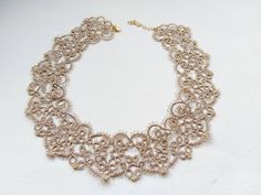 The very delicate gold lace necklace is a stunning piece of handmade jewelry that features a delicate and intricate design. The necklace is crafted using the traditional art of tatting, which involves hundreds of individual stitches to create a delicate and refined look. The gold lace of the necklace is made from high-quality German Madeira metallic gold thread, which sparkles beautifully when exposed to certain types of light.  The necklace has a vintage-inspired style reminiscent of Victorian- Handmade Yellow Gold Bridal Necklace For Wedding, Ornate Gold Choker For Wedding, Gold Choker With Intricate Design For Wedding, Gold Wedding Choker With Intricate Design, Delicate Gold Bridal Necklace For Party, Ornate Gold Choker With Intricate Design, Ornate Gold Choker As Gift, Gold Filigree Necklace For Wedding, Handmade Gold Necklaces For Wedding