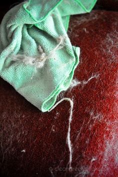 a piece of cloth is sitting on top of a red surface with white thread in it