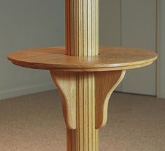 a round wooden table sitting on top of a carpeted floor