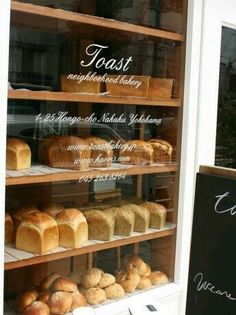 a bakery display case filled with lots of different types of bread