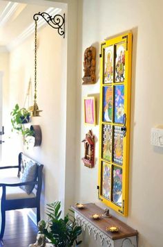 a yellow door is hanging on the wall next to a blue chair and some plants