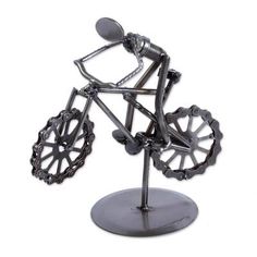 a metal sculpture of a person riding a bike on a stand with wheels and spokes