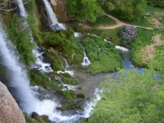 a waterfall is seen from above in the woods