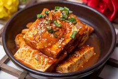 tofu with sauce and green onions in a bowl