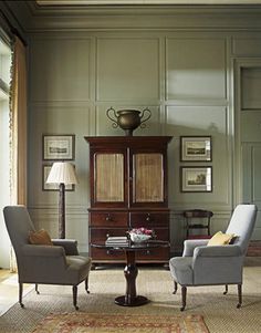 a living room with two chairs and a cabinet in it's centerpieces