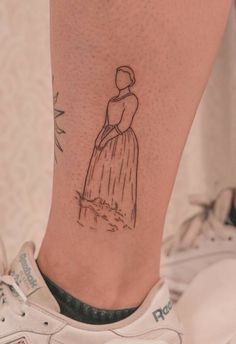 a woman's foot with a small tattoo on her left leg and an image of a dress