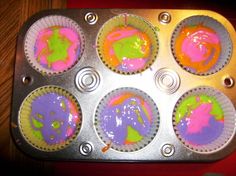 cupcake tins with colorful frosting in them