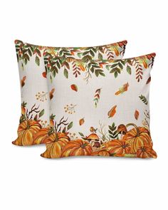 two pillows with pumpkins and leaves on them