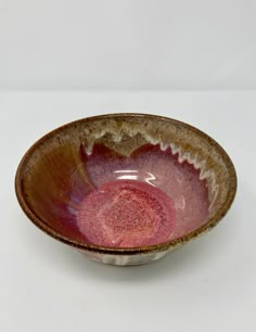 a brown and pink bowl sitting on top of a white table