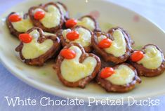 white chocolate pretzel ducks on a plate with orange and red candies in the shape of hearts