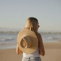 a woman wearing a hat on the beach