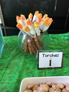 there is a bowl full of cookies and some candy sticks on the table next to it