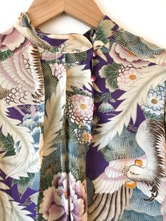 Lovely lavender blouse with floral and bird motif. Interesting asymmetrical button front. Has a wonderful drape. Fabric: Rayon crepe Label: First GlanceFit: S/M Measurements (flat): Armpit to armpit 18” Sleeve 23” Shoulder (across) 15”Cuff opening (buttoned) 3” Length (front) 22”Length (back) 24.5” Waist 18” Condition: Excellent Purple Floral Print Top For Daywear, Printed Silk Blouse For Daywear, Silk Printed Blouse For Daywear, Drape Fabric, Lavender Blouse, Lovely Lavender, Bird Motif, Floral Blouse, Floral Tops