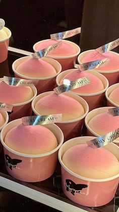 pink ice cream cups with labels on them sitting in a display case at a store