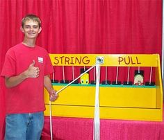 a man standing in front of a string pull machine with two strings attached to it