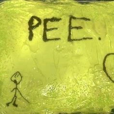 a cake with writing on it that says pee and a person walking in the background