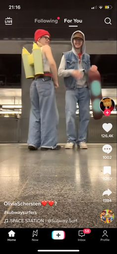 two people are standing in an airport with their backs turned to the camera and one person is wearing a hoodie