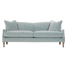 a light blue couch with two pillows on the back and one arm upholstered