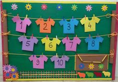 a bulletin board with clothes hanging on the clothesline and numbers pinned to it's sides