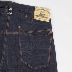 Roughly translated, ‘nonpareil’ means without equal or unmatched, and it is easy to see why it applies to these jeans. Brown-Duck & Digger have launched a jean with all charming characteristics of denim’s earliest years, a vintage inspired masterpiece which will take you back in time. This straight leg, mid rise jean is packed with features such as a one-pice button fly construction, side sewn selvedge line, cinch back, over seam riveted back pockets and watch pocket, and custom made cotton bran Jeans Back Pocket Design, Americana Fashion Men, Selvage Denim Jeans, Boho Men Style, Front Pocket Design, Orange Jeans, Selvage Denim, Workwear Vintage, Watch Pocket