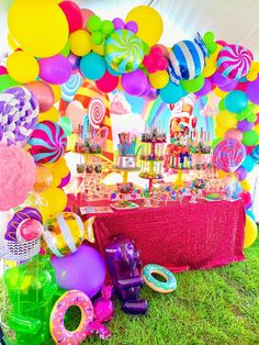 a table topped with lots of candy and balloons