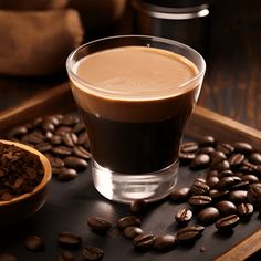 a cup of coffee sitting on top of a wooden tray next to some coffee beans