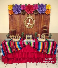 the table is decorated with colorful paper flowers and an acrobatic name sign