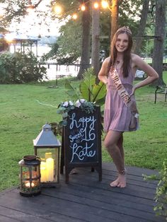 a woman standing next to a chalkboard sign