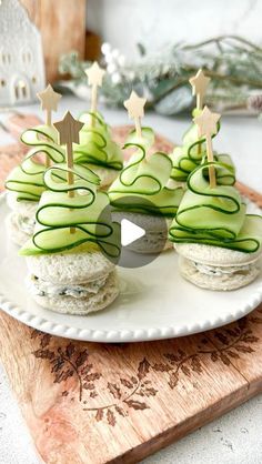 cucumber and cheese sandwiches on a plate with wooden sticks in the shape of trees