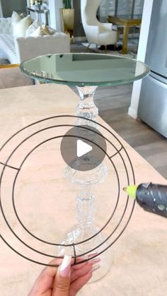 a person is holding a wine glass in front of a table with an object on it