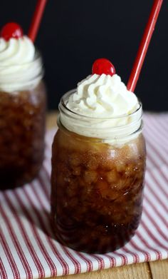 two glasses filled with dessert sitting on top of a table