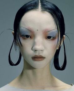 a woman with white makeup and black hair