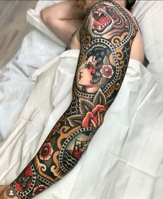 a person laying in bed with a tattoo on their arm