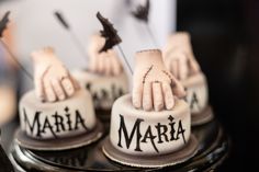 three cakes decorated with hands and the word maria on them are sitting on a table