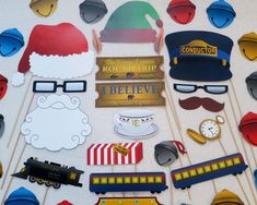 a table topped with paper cut outs and hats, glasses, santa clause hat, train