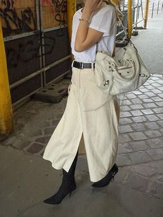 a woman is talking on her cell phone while walking down the street with a handbag